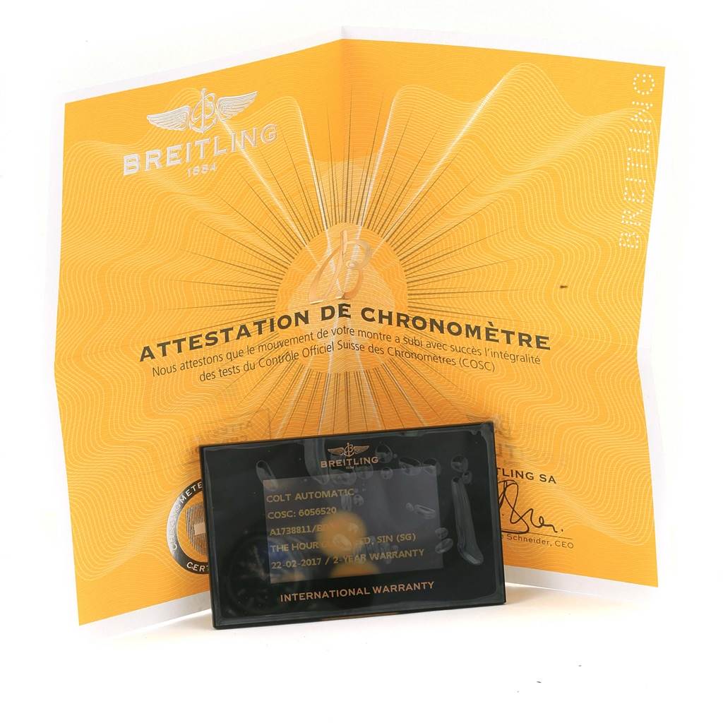 The image shows the Breitling Colt A17388 Men
s Stainless Steel Black Dial A17388 Men
s Stainless Steel Black Dial model
s certification papers and warranty card placed on top of them.