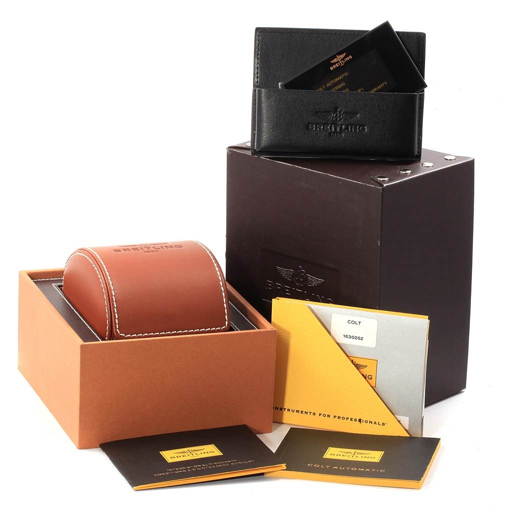 The image shows the packaging, documents, and accessories for the Breitling Colt A17388 Men's Stainless Steel White Dial A17388 Men's Stainless Steel White Dial watch, including a leather case and warranty card.