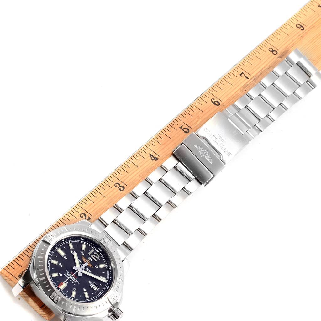 The Breitling Colt A17388 Men's Stainless Steel Black Dial A17388 Men's Stainless Steel Black Dial watch is shown from above, displaying its face, bezel, and stainless steel bracelet alongside a wooden ruler for scale.