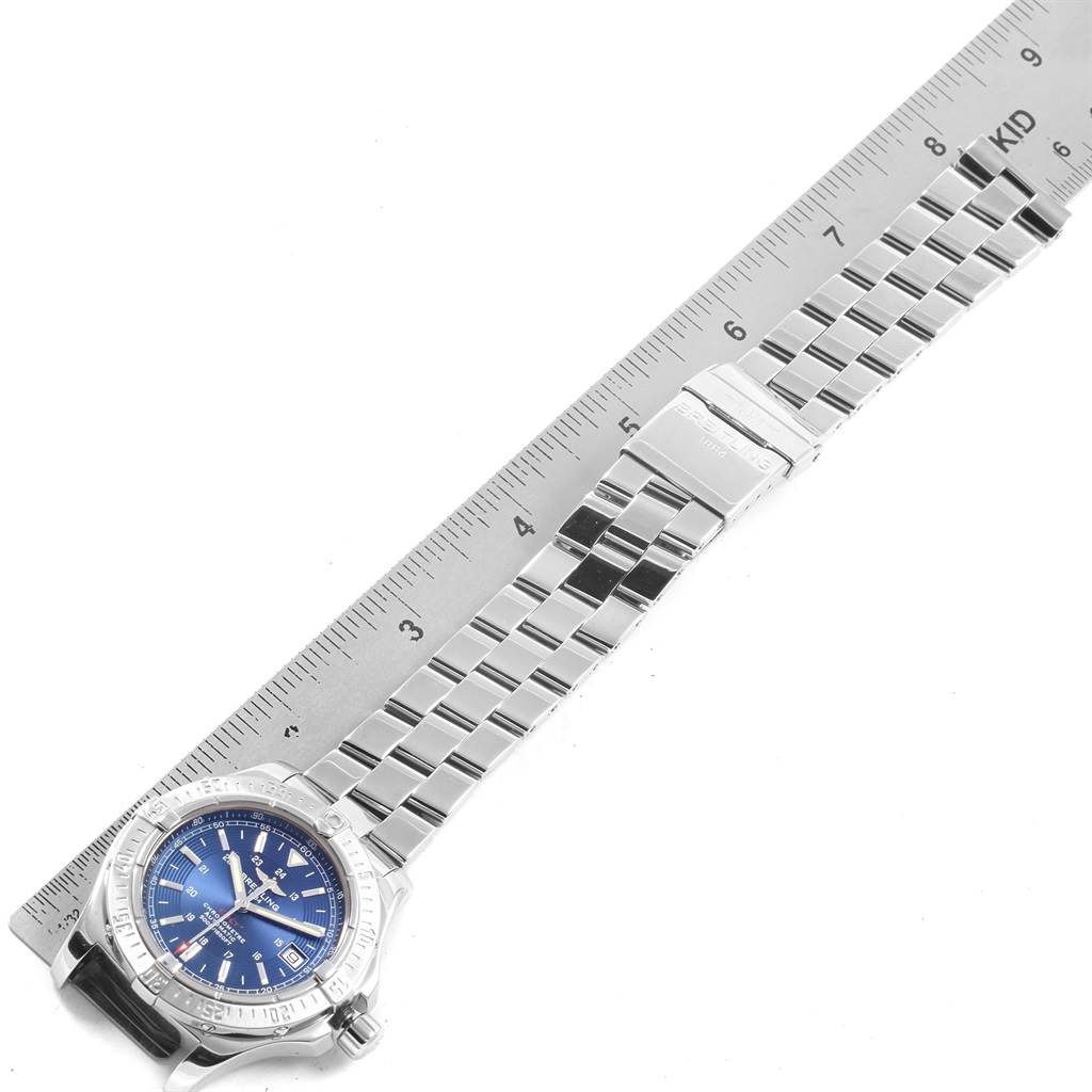 This image shows a Breitling Colt A17380 Men's Stainless Steel Blue Dial A17380 Men's Stainless Steel Blue Dial watch laid flat next to a ruler, displaying its metal bracelet and blue dial from a top-down angle.