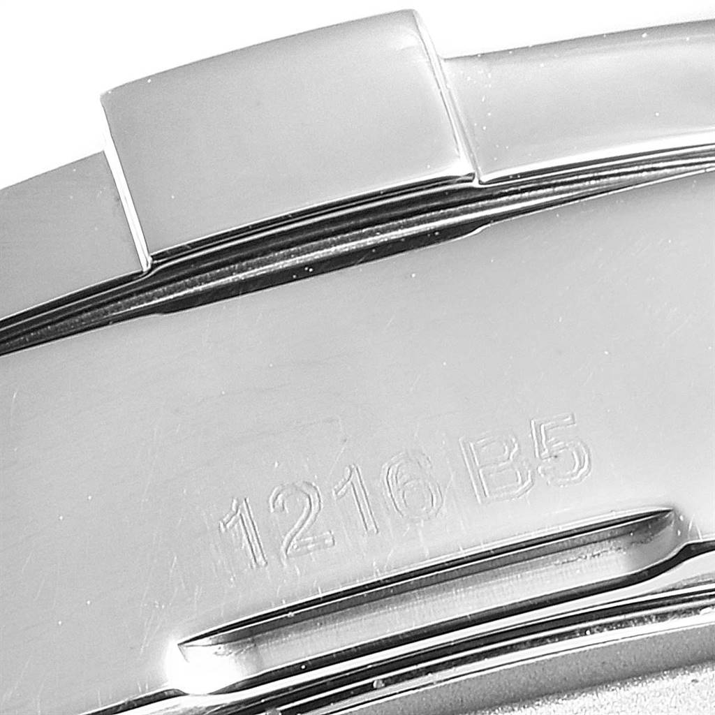 This is a close-up image of a metallic clasp or part of the bracelet for the Breitling Colt A17313 Men's Stainless Steel White Dial A17313 Men's Stainless Steel White Dial watch featuring an engraved code.
