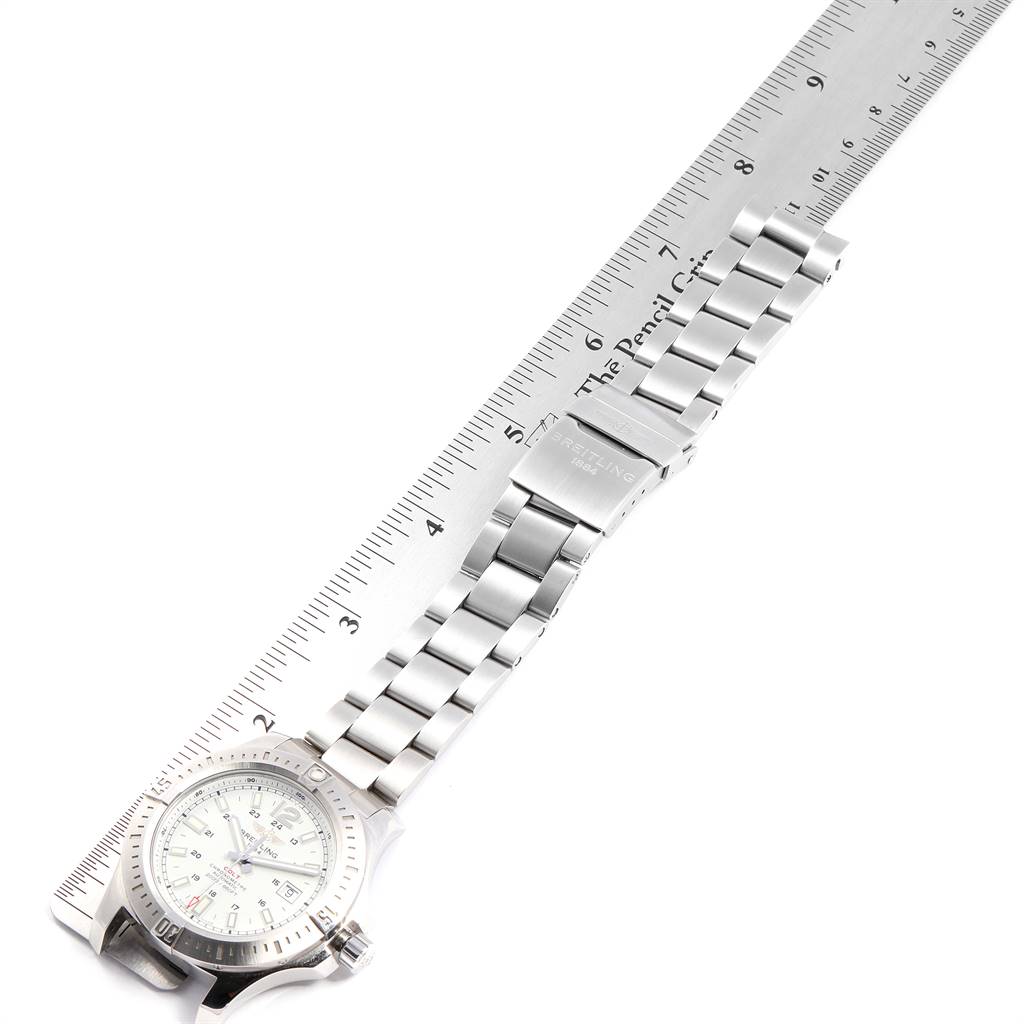 The image shows a Breitling Colt A17388 Men's Stainless Steel White Dial A17388 Men's Stainless Steel White Dial watch laid flat next to a ruler, displaying its face, case, and metal bracelet.