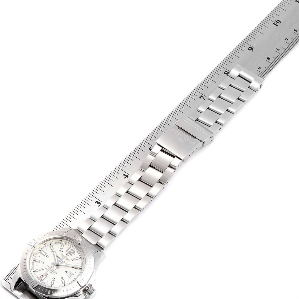 The image shows a Breitling Colt A17388 Men's Stainless Steel White Dial A17388 Men's Stainless Steel White Dial watch laid flat next to a ruler, displaying its band and face at an angle.