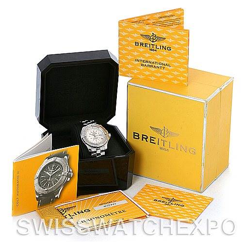 The Breitling Colt A17380 Men's Stainless Steel White Dial A17380 Men's Stainless Steel White Dial watch is displayed in an open box, along with its yellow packaging and various warranty and instruction booklets.
