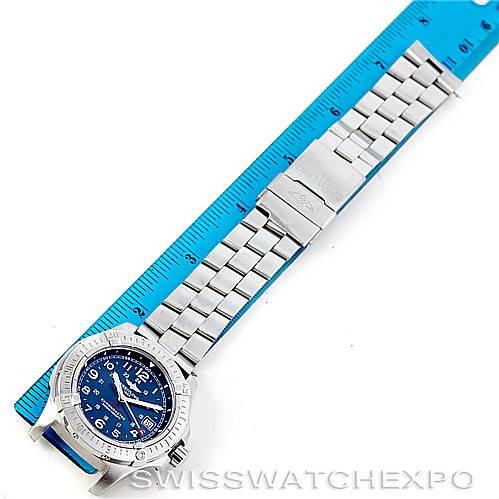 The image shows the entire Breitling Colt A74380 Men's Stainless Steel Blue Dial A74380 Men's Stainless Steel Blue Dial watch laid flat next to a blue ruler for scale.