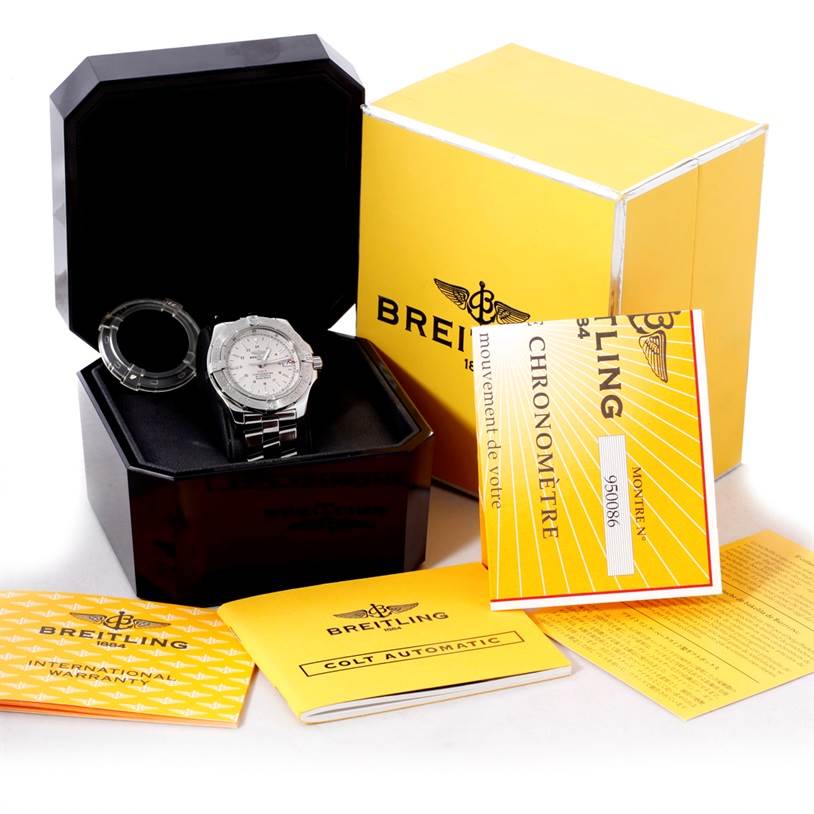 The image shows a Breitling Colt A17380 Men
s Stainless Steel Silver Dial A17380 Men
s Stainless Steel Silver Dial watch in a box, with its yellow packaging and accompanying manuals displayed.