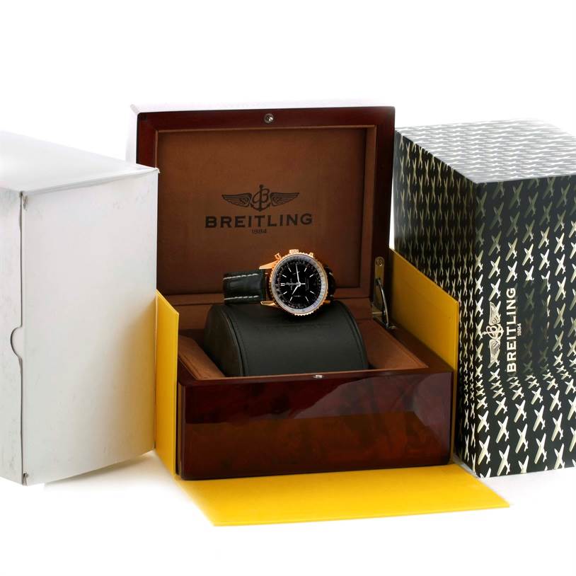 The Breitling Navitimer R26322 Men's Rose Gold Black Dial R26322 Men's Rose Gold Black Dial watch is displayed front-facing in an open box beside additional packaging.