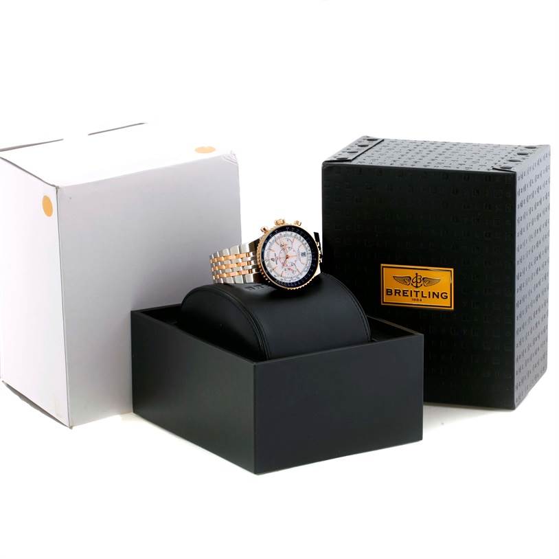 The image shows a Breitling Navitimer C23340 Men
s Steel and Gold (two tone) Silver Dial C23340 Men
s Steel and Gold (two tone) Silver Dial watch displayed at an angle in its packaging, including a black cushion and two branded boxes.