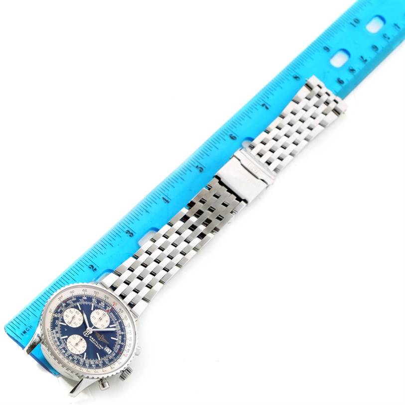 The image shows a Breitling Navitimer A13022 Men
s Stainless Steel Blue Dial A13022 Men
s Stainless Steel Blue Dial watch laid flat, including the face, bezel, and metal bracelet next to a blue ruler.