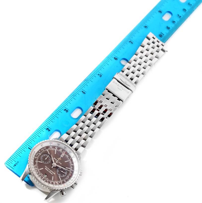 The image shows the Breitling Navitimer A26322 Men's Stainless Steel Brown Dial A26322 Men's Stainless Steel Brown Dial watch laid flat next to a ruler, displaying the face, bezel, and bracelet.