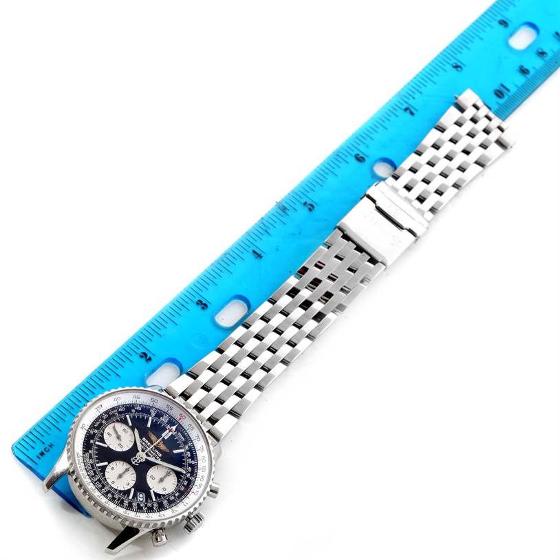 The image shows a top view of a Breitling Navitimer A23322 Men's Stainless Steel Black Dial A23322 Men's Stainless Steel Black Dial watch with its metal strap and a blue ruler placed alongside.