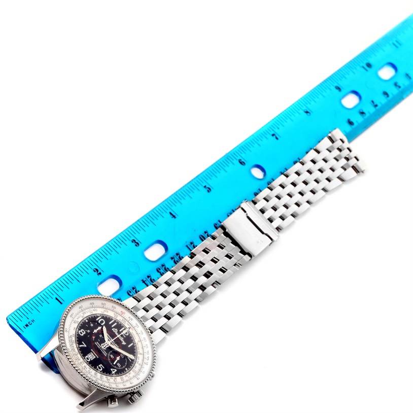 The image shows a Breitling Navitimer A35330 Men's Stainless Steel Black Dial A35330 Men's Stainless Steel Black Dial watch at a top-down angle, including its face and the metal bracelet lying next to a blue ruler.