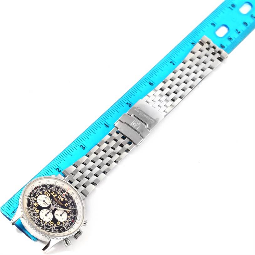 The image shows the entire Breitling Navitimer A12022 Men
s Stainless Steel Black Dial A12022 Men
s Stainless Steel Black Dial watch, including the face, bezel, and metal bracelet, next to a blue ruler.