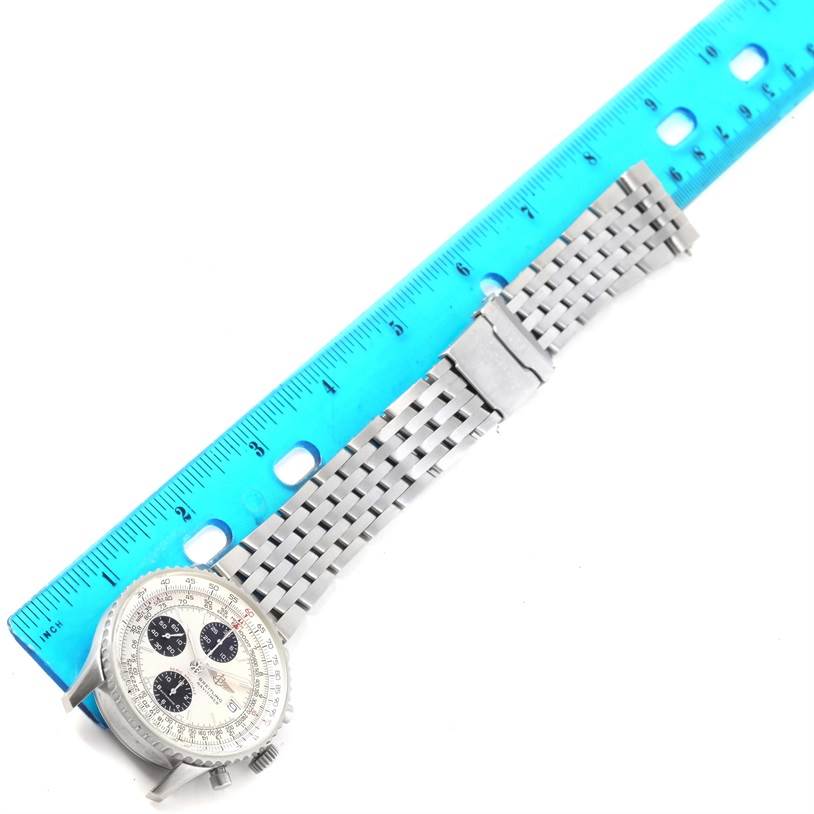 The image shows the Breitling Navitimer A13330 Men
s Stainless Steel Silver Dial A13330 Men
s Stainless Steel Silver Dial watch laid flat, with its metal bracelet fully extended alongside a blue ruler.