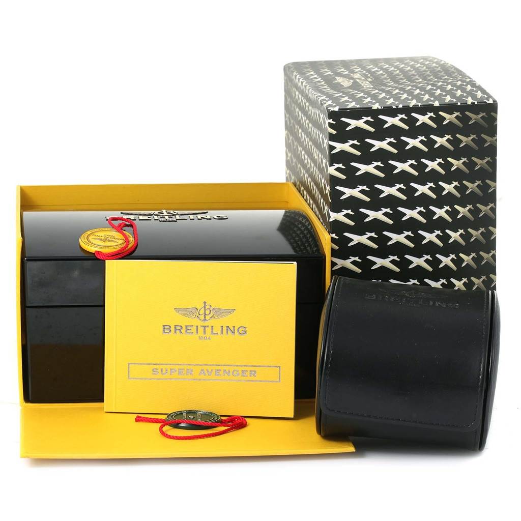 The image shows the packaging and accessories of a Breitling Navitimer C23340 Men's Steel and Gold (two tone) Silver Dial C23340 Men's Steel and Gold (two tone) Silver Dial, including a box, a booklet, and a travel case.