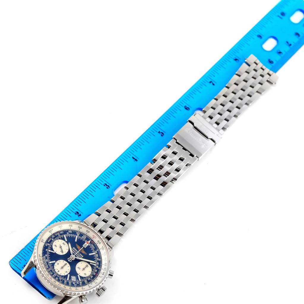 The Breitling Navitimer A23322 Men's Stainless Steel Blue Dial A23322 Men's Stainless Steel Blue Dial watch is shown flat with its entire metal bracelet extended alongside a blue ruler.