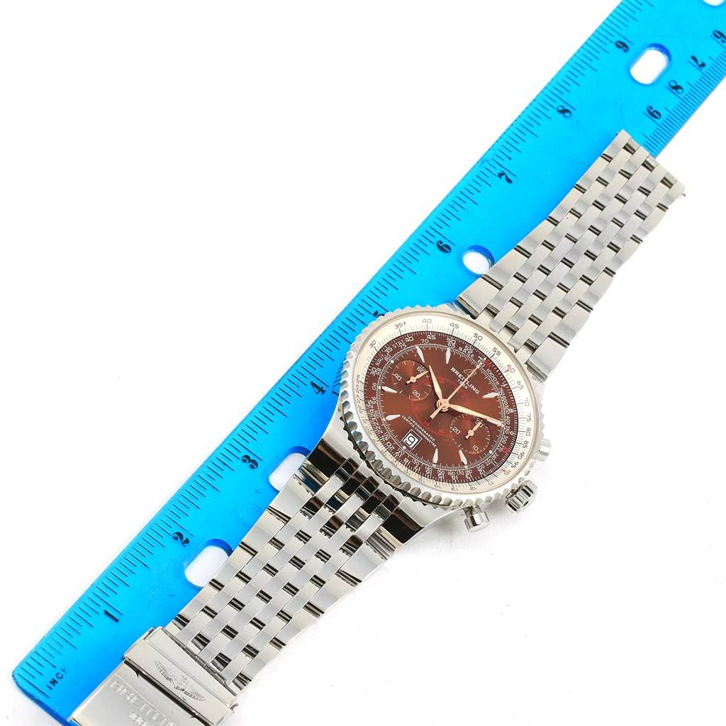 The Breitling Navitimer A23340 Men
s Stainless Steel Brown Dial A23340 Men
s Stainless Steel Brown Dial watch is displayed flat with its face, bezel, and metal bracelet visible next to a blue ruler.