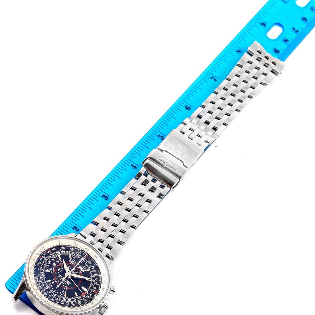 The image shows the full length of a Breitling Navitimer A21330 Men's Stainless Steel Silver Dial A21330 Men's Stainless Steel Silver Dial watch, including its face and metal strap, beside a blue ruler.