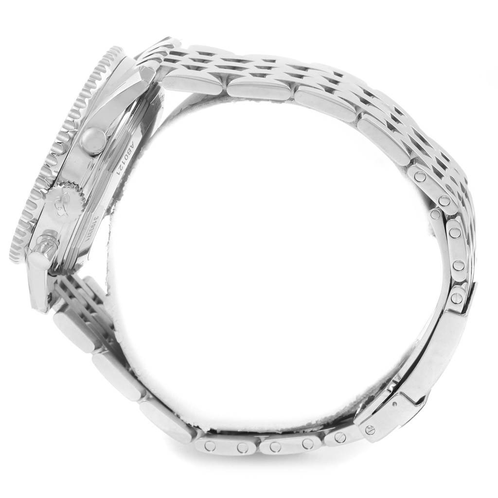 The image shows a side view of the Navitimer watch by Breitling, focusing on the case, crown, bezel, and metal bracelet.