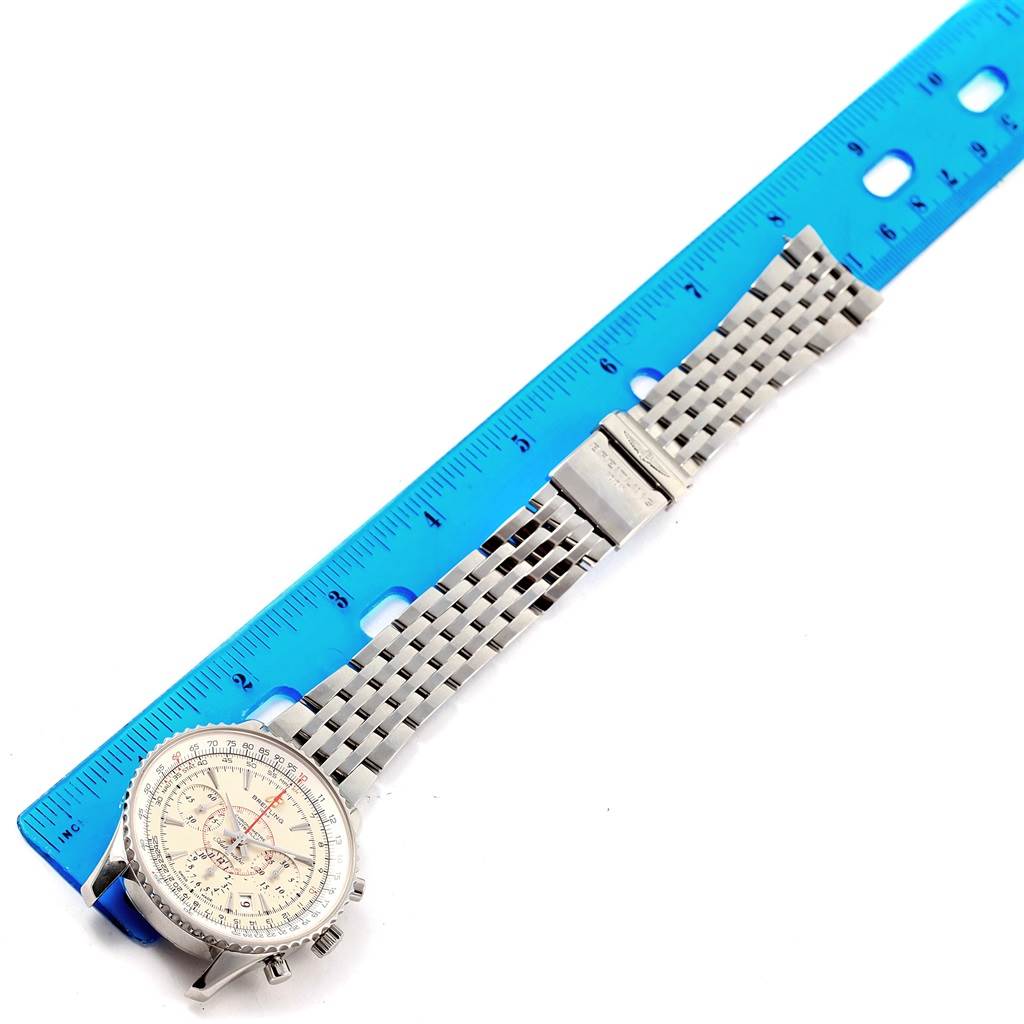 The image shows a top view of a Breitling Navitimer AB0131 Men's Stainless Steel Silver Dial AB0131 Men's Stainless Steel Silver Dial watch with a stainless steel bracelet alongside a ruler for size reference.