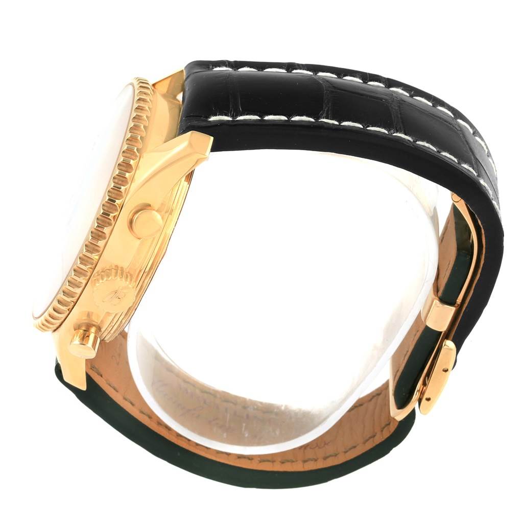 The image shows a side view of the Breitling Navitimer K24322 Men's Yellow Gold Black Dial K24322 Men's Yellow Gold Black Dial watch, highlighting the gold case, crown, pushers, and leather strap.