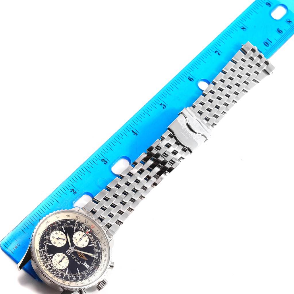 The photo shows a Breitling Navitimer A13322 Men
s Stainless Steel Black Dial A13322 Men
s Stainless Steel Black Dial watch face and bracelet laid flat next to a blue ruler for scale.