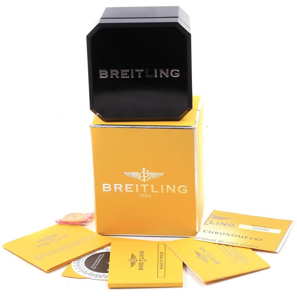 The image shows a Breitling Navitimer A23322 Men's Stainless Steel Black Dial A23322 Men's Stainless Steel Black Dial watch set, including a watch box on top of a yellow Breitling box, surrounded by booklets and accessories.