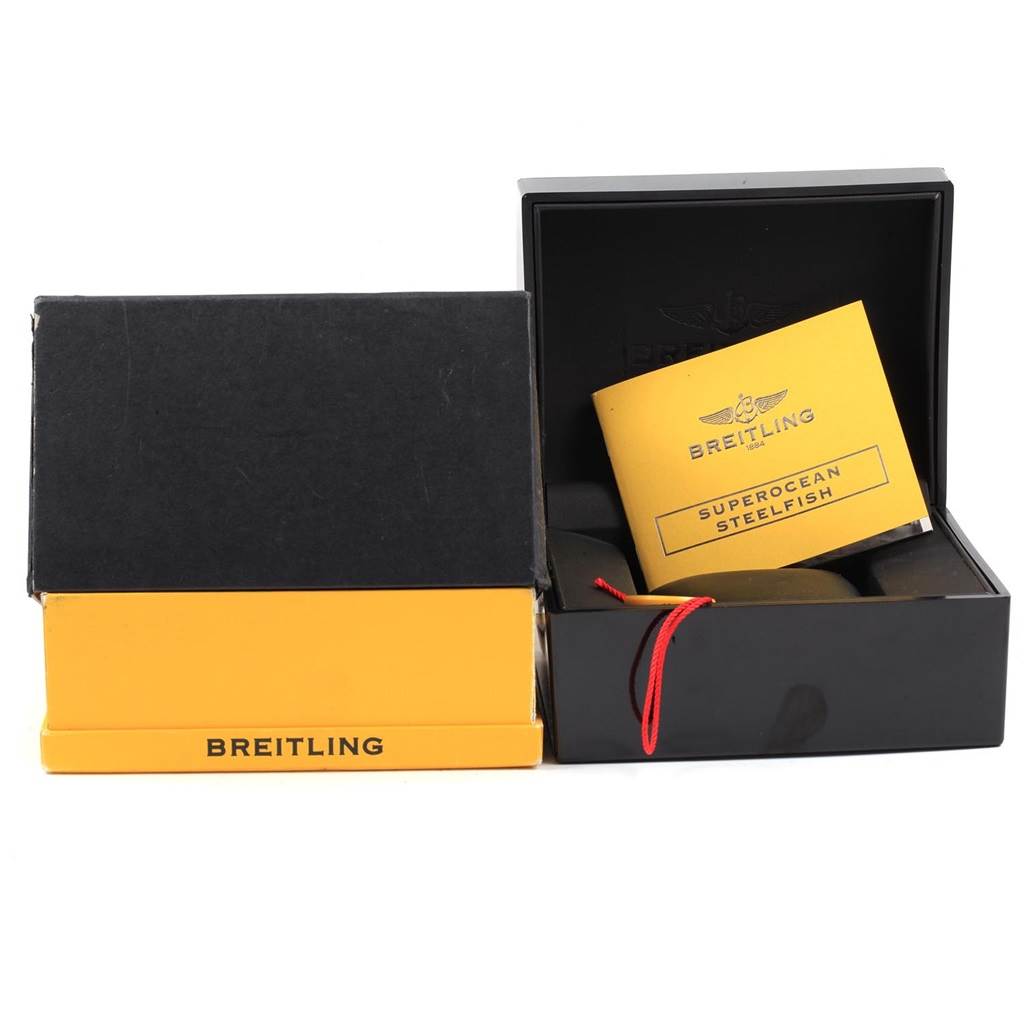 The image shows the packaging and manuals of a Breitling Navitimer A13322 Men
s Stainless Steel Black Dial A13322 Men
s Stainless Steel Black Dial watch, including an open box and a Superocean Steelfish booklet.