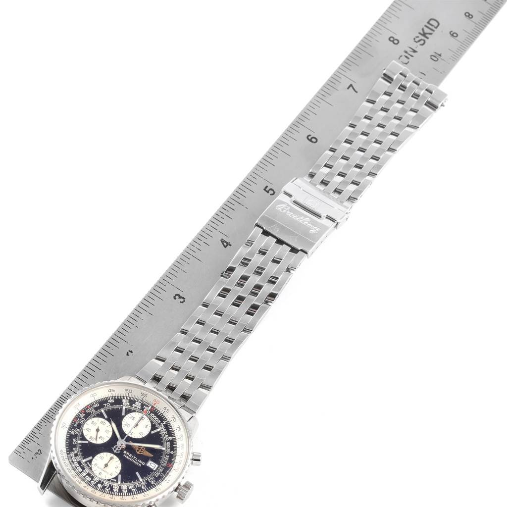 The image shows a Breitling Navitimer A13322 Men
s Stainless Steel Black Dial A13322 Men
s Stainless Steel Black Dial watch laid flat alongside a ruler, highlighting its face, bezel, and metal bracelet.
