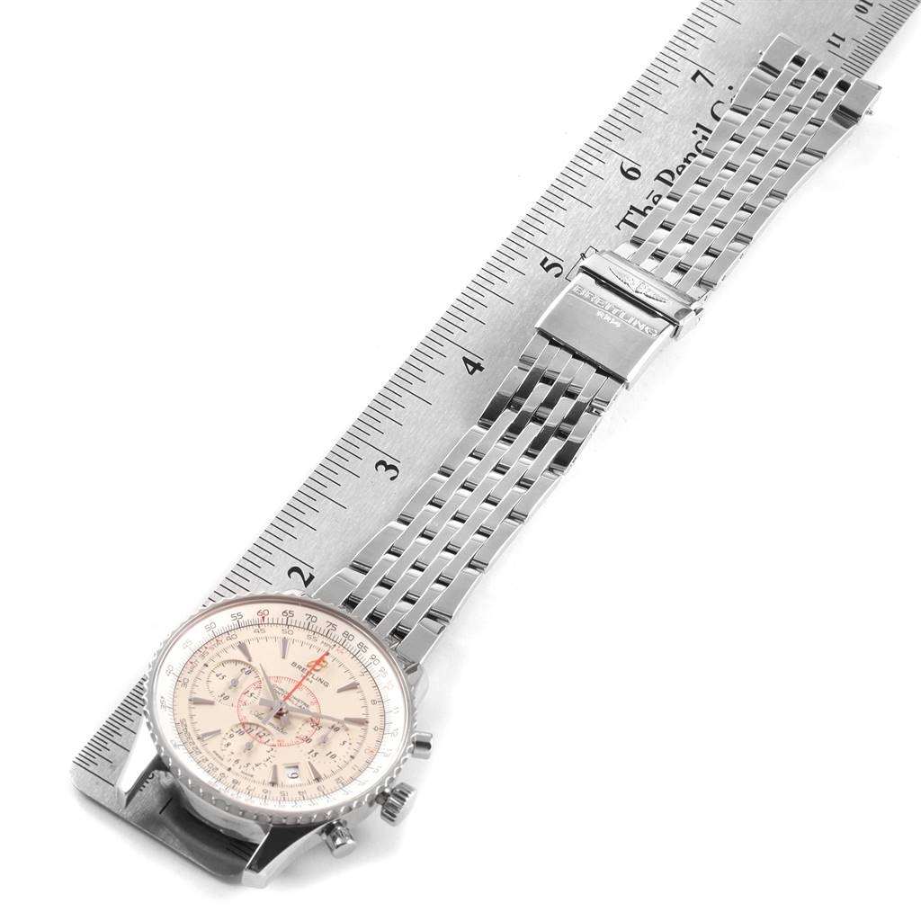 The image shows a Breitling Navitimer AB0131 Men's Stainless Steel Silver Dial AB0131 Men's Stainless Steel Silver Dial watch with a metal bracelet and a clasp, placed on a measuring scale.