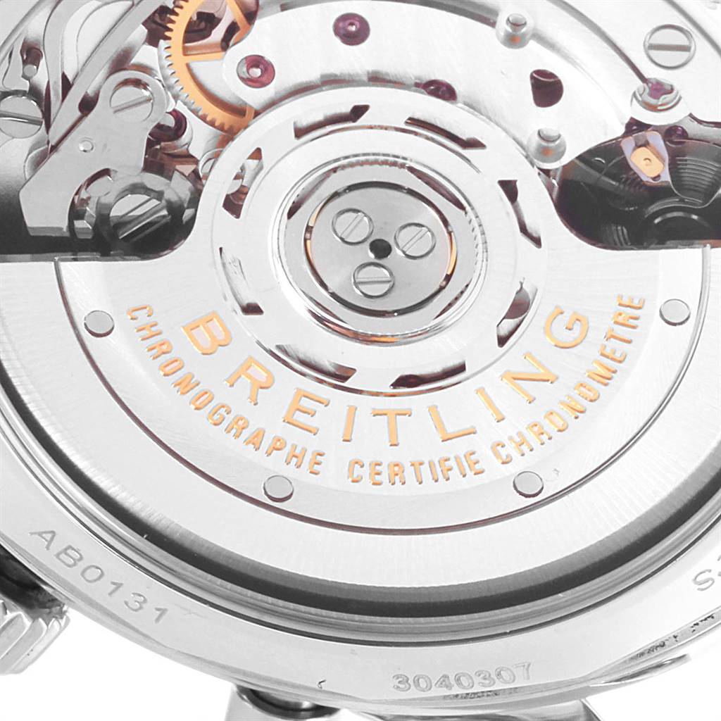 The image shows a close-up view of the Breitling Navitimer AB0131 Men's Stainless Steel Silver Dial AB0131 Men's Stainless Steel Silver Dial watch's movement with visible branding and mechanical parts.
