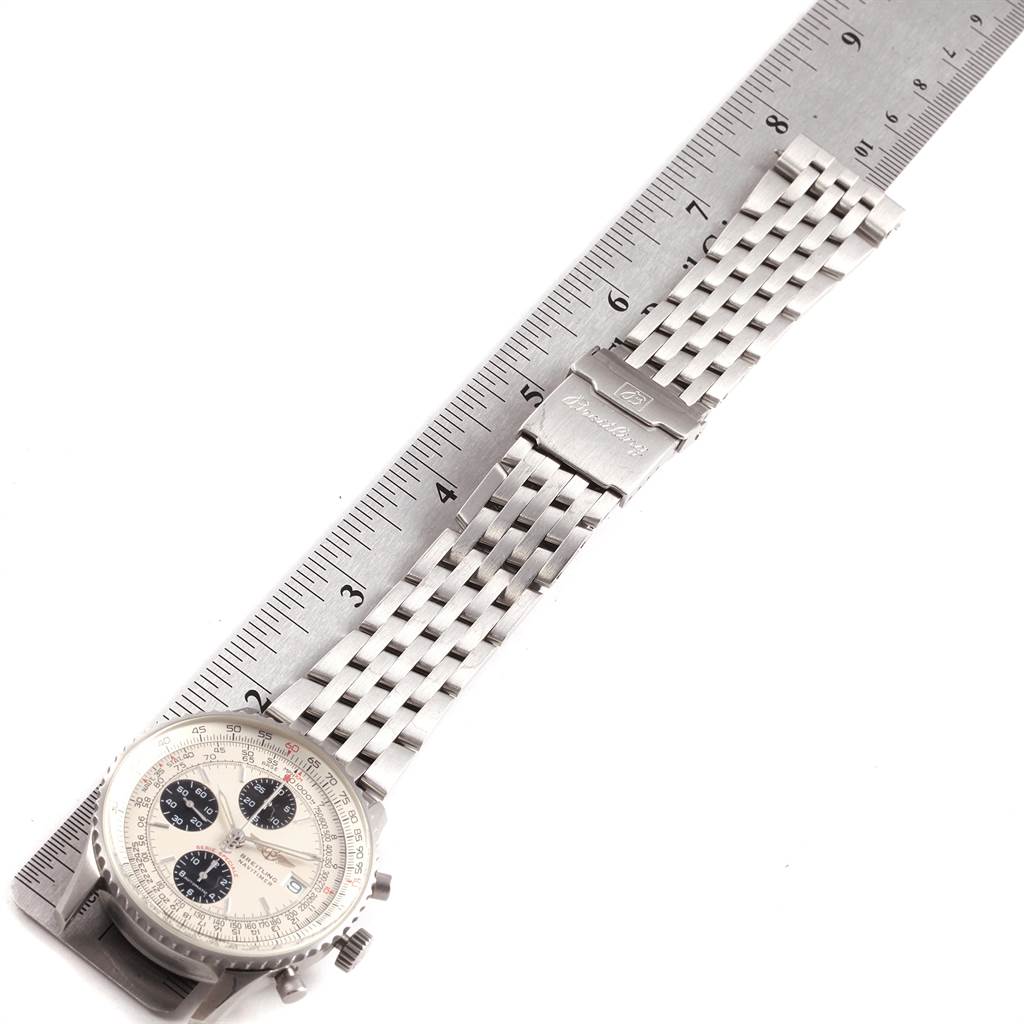 The image shows a Breitling Navitimer A13330 Men's Stainless Steel Silver Dial A13330 Men's Stainless Steel Silver Dial watch with its stainless steel strap laid alongside a ruler.
