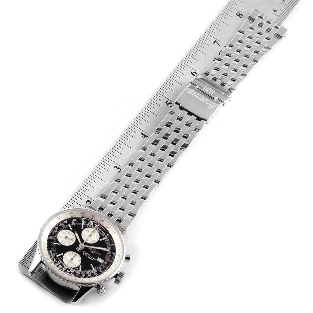 The image shows a Breitling Navitimer A13322 Men's Stainless Steel Black Dial A13322 Men's Stainless Steel Black Dial watch from a top-down angle, highlighting its face and partly extended metal bracelet with a measurement ruler beside it.