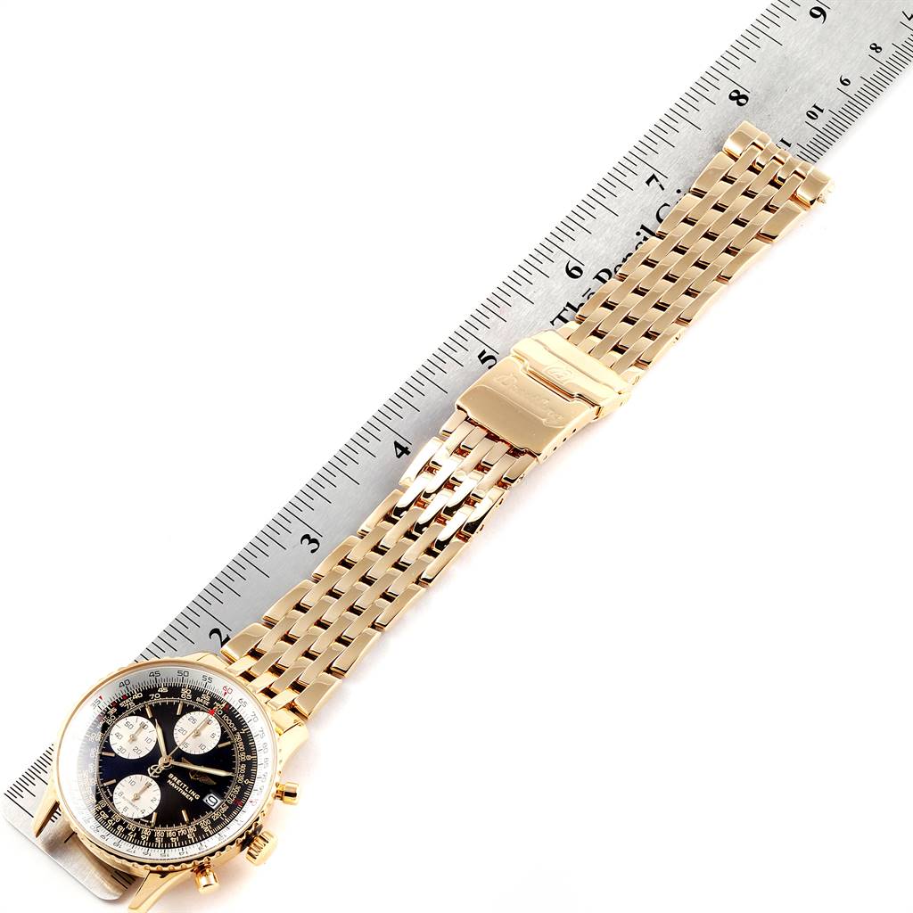 The image shows a Breitling Navitimer K13022 Men's Yellow Gold Black Dial K13022 Men's Yellow Gold Black Dial watch with a gold bracelet laid next to a ruler for scale.