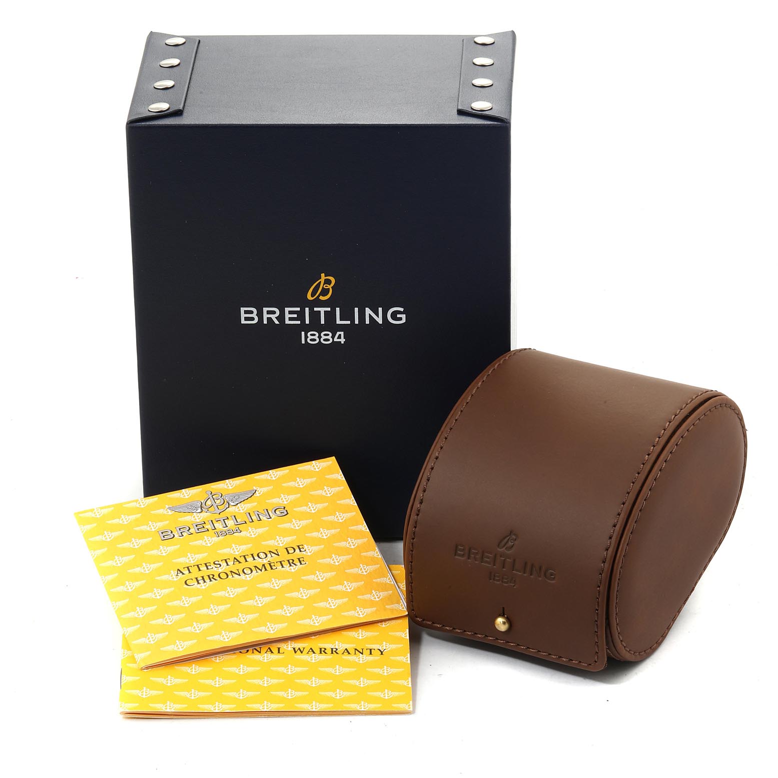 This image shows the Breitling Navitimer H13330 Men's Yellow Gold Black Dial H13330 Men's Yellow Gold Black Dial watch box, a brown leather case, and two yellow warranty booklets.