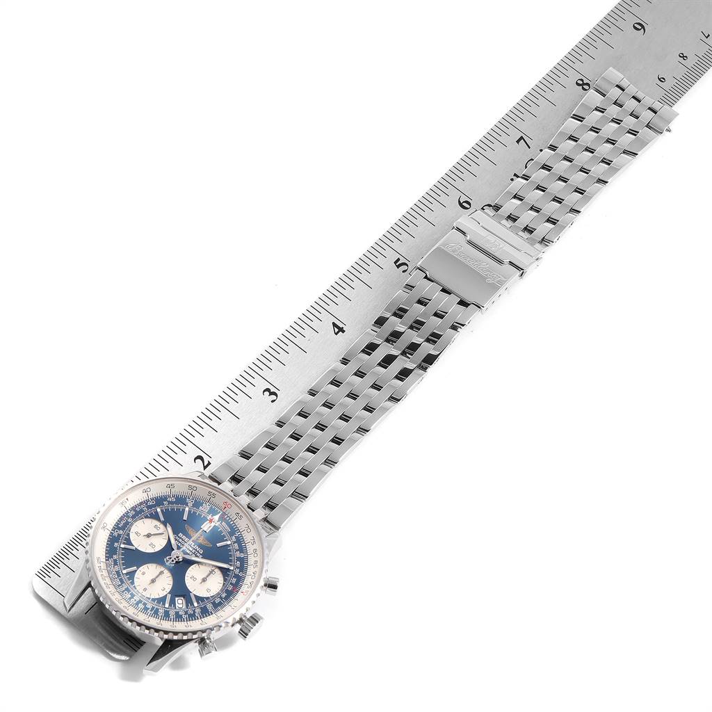 This image shows a Breitling Navitimer A23322 Men
s Stainless Steel Blue Dial A23322 Men
s Stainless Steel Blue Dial watch with a blue dial and a stainless steel bracelet laid parallel to a ruler.