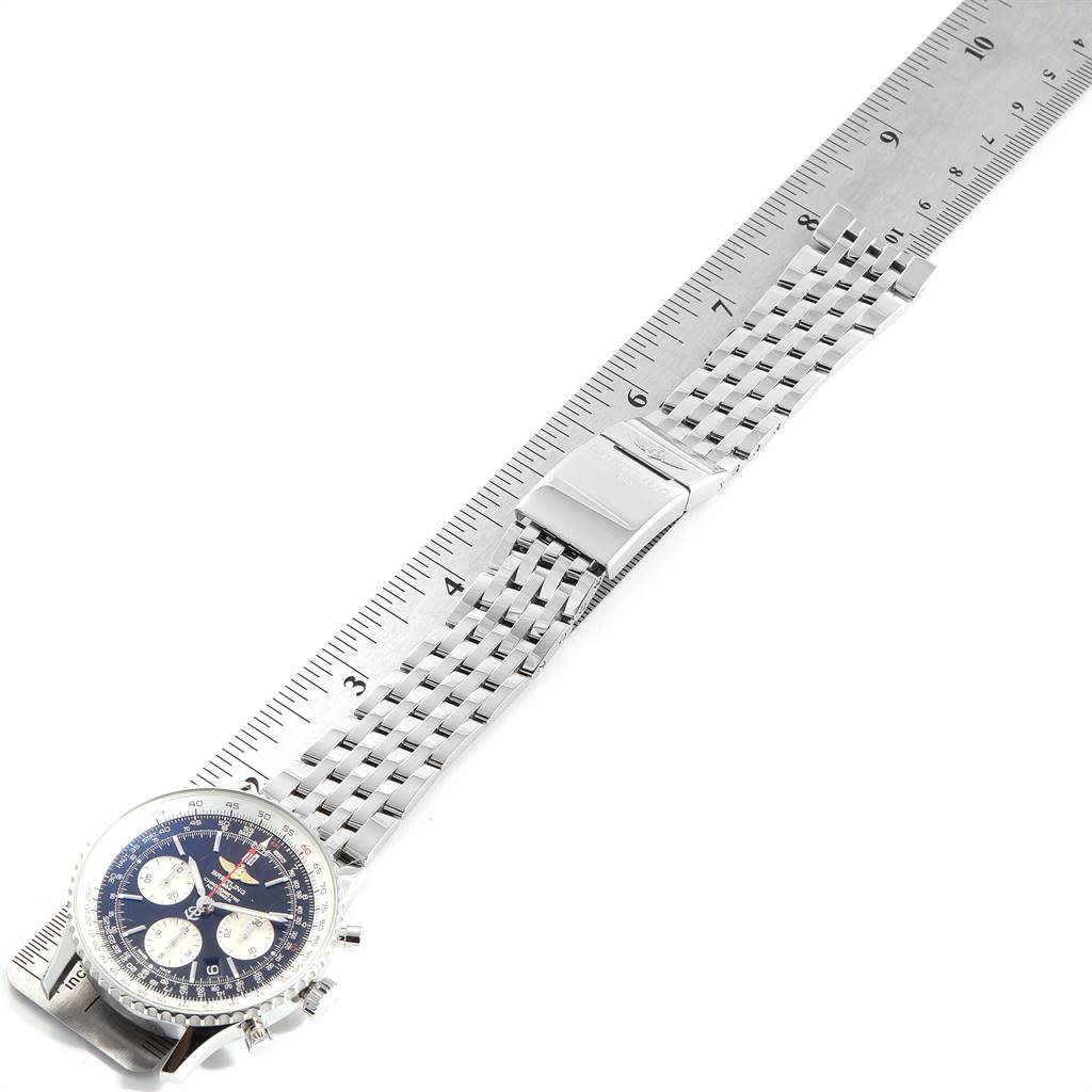 This image shows a Breitling Navitimer AB0121 Men
s Stainless Steel Black Dial AB0121 Men
s Stainless Steel Black Dial watch partially, with its metal bracelet and buckle placed alongside a ruler.