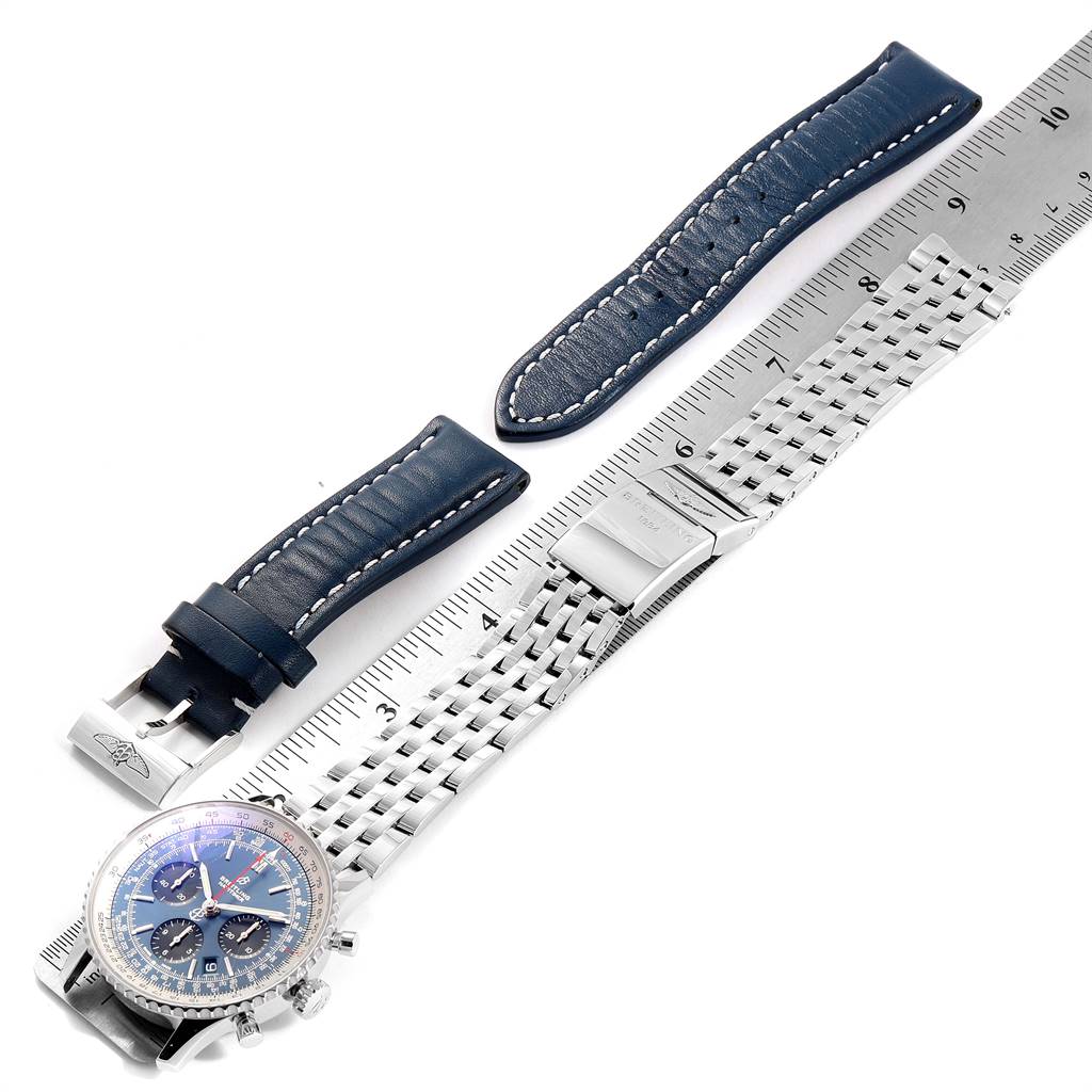 The image shows a Breitling Navitimer AB0121211C1A1 Men's Stainless Steel Blue Dial AB0121211C1A1 Men's Stainless Steel Blue Dial watch with a blue leather strap and a metal bracelet laid out next to a ruler.