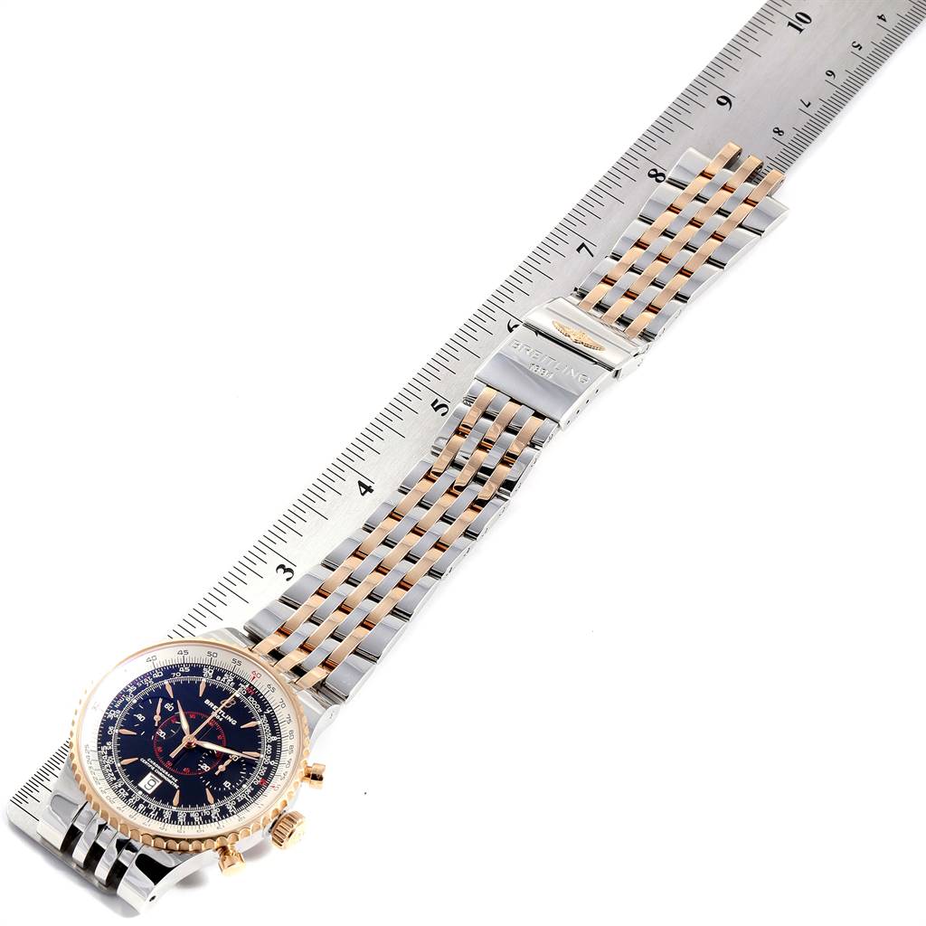 The image shows a top view of the Breitling Navitimer C23340 Men
s Steel and Gold (two tone) Black Dial C23340 Men
s Steel and Gold (two tone) Black Dial watch, focusing on its band measured against a ruler.