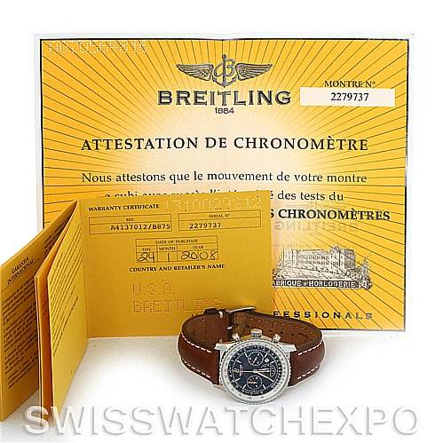 This image shows a Breitling Navitimer A4137012/B875 Men's Stainless Steel Black Dial A4137012/B875 Men's Stainless Steel Black Dial watch, placed in front of its warranty certificate and chronometer attestation.