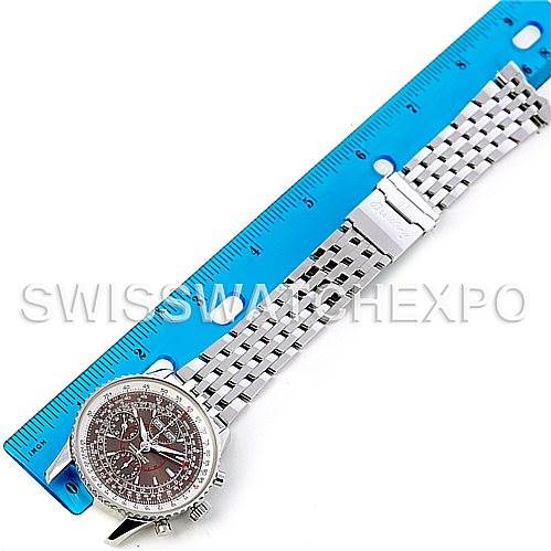 The image shows a top-down view of the Breitling Navitimer A21330 Men
s Stainless Steel Brown Dial A21330 Men
s Stainless Steel Brown Dial watch displaying the face, bezel, and metal bracelet alongside a blue ruler.