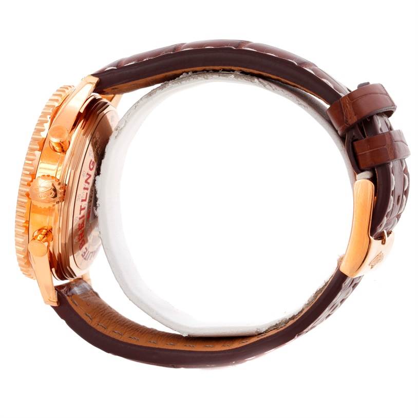 The image shows the side view of a Breitling Navitimer RB0120 Men's Rose Gold Black Dial RB0120 Men's Rose Gold Black Dial watch highlighting the crown, pushers, case, and leather strap with a clasp.