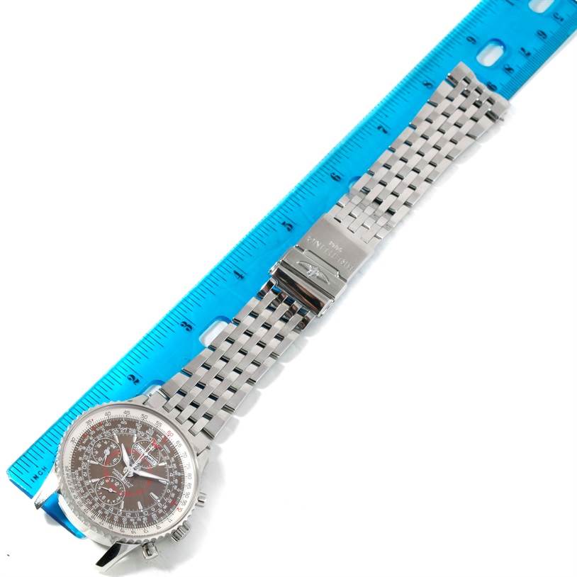 The image shows a Breitling Navitimer A21330 Men's Stainless Steel Brown Dial A21330 Men's Stainless Steel Brown Dial watch laid flat with a metal band and a blue ruler for size reference.