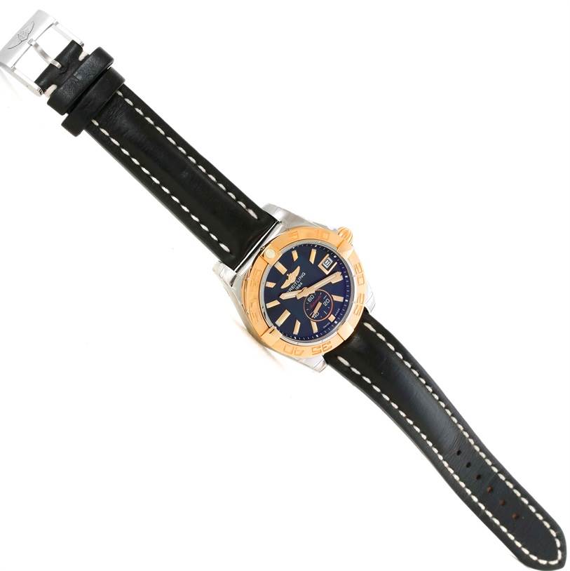 The Breitling Galactic C37330 Men's Steel and Gold (two tone) Black Dial C37330 Men's Steel and Gold (two tone) Black Dial watch is shown from a top view, displaying its black leather strap, gold bezel, and blue dial.