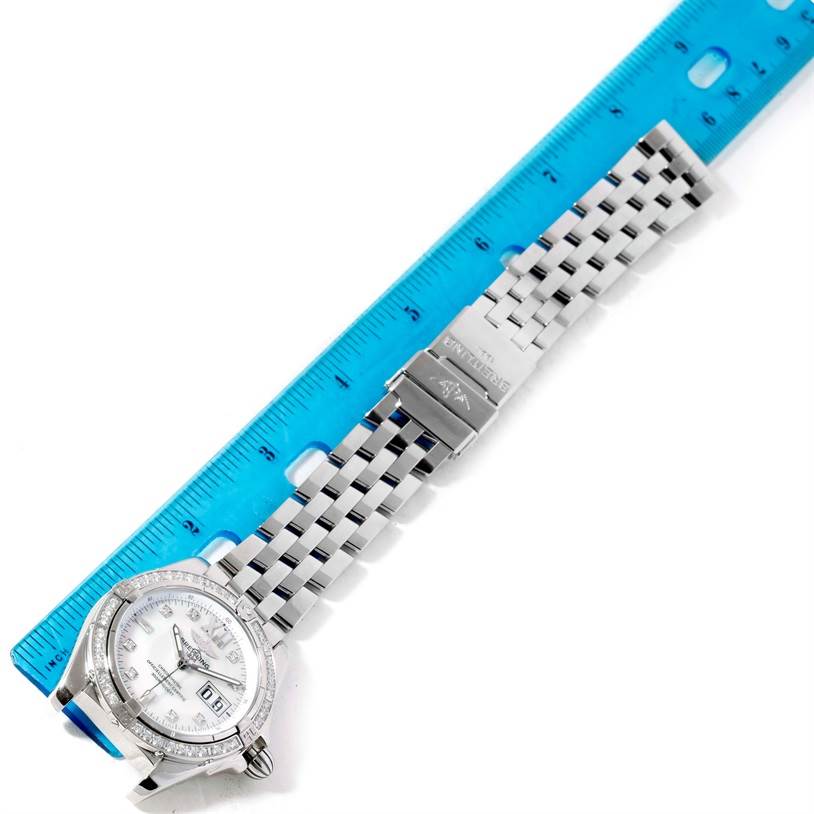 The image shows a Breitling Windrider A49350 Men's Stainless Steel Mother of Pearl Dial A49350 Men's Stainless Steel Mother of Pearl Dial watch laid flat, highlighting the face, metal bracelet, and clasp alongside a blue ruler.