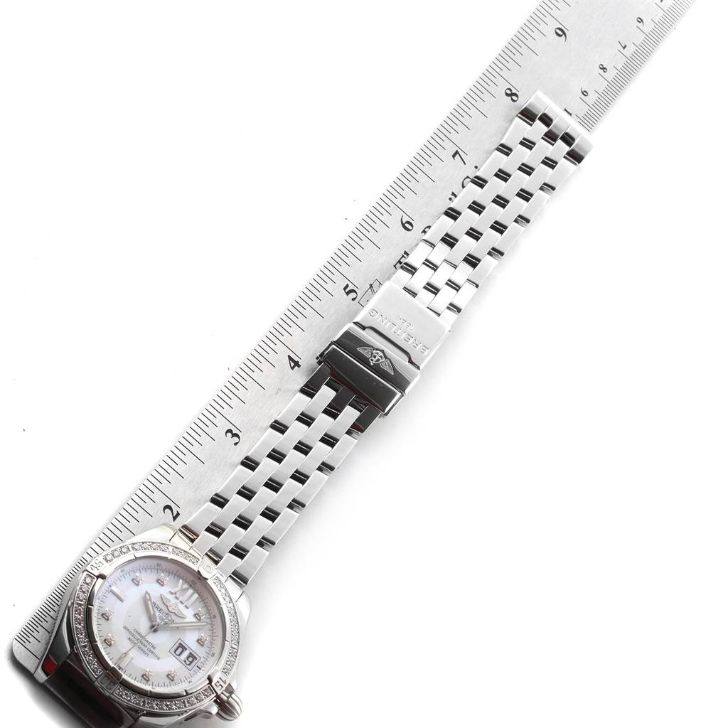 The Breitling Windrider A49350LA/A702-366A Men's Stainless Steel Mother of Pearl Dial A49350LA/A702-366A Men's Stainless Steel Mother of Pearl Dial watch is shown from a top-down angle, displaying the face, bracelet, and clasp alongside a ruler for scale.