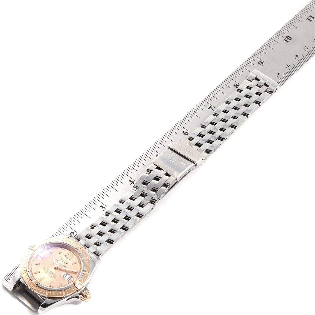 The image shows the Breitling Windrider C49350 Men's Steel and Gold (two tone) Champagne Dial C49350 Men's Steel and Gold (two tone) Champagne Dial watch laid flat on its band alongside a ruler, highlighting its length and bracelet details.