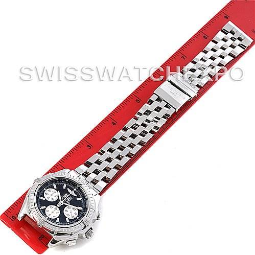 The image shows a top-down angle of a Breitling Windrider A4435512 Men's Stainless Steel Black Dial A4435512 Men's Stainless Steel Black Dial watch with its silver metal bracelet alongside a red ruler.