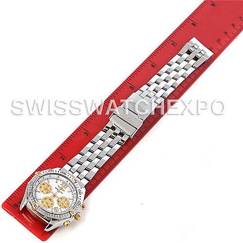 This image shows a Breitling Windrider B55048 Men's Steel and Gold (two tone) White Dial B55048 Men's Steel and Gold (two tone) White Dial watch laid flat against a red ruler, displaying the band, clasp, and face from a top-down angle.