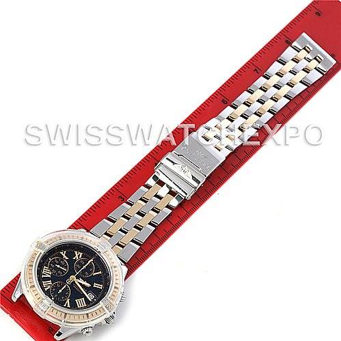 The image shows a top-down view of a Breitling Windrider D1335512 Men's Steel and Gold (two tone) Black Dial D1335512 Men's Steel and Gold (two tone) Black Dial model watch laid on a red ruler.